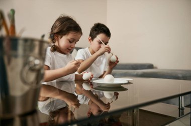 Evde paskalya yumurtası süsleyen iki güzel çocuk. Geleneksel dini etkinlik.