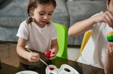 Paskalya için evde yumurta boyayan neşeli kız. Resim yapmak. Sanat, çocukluk kavramı