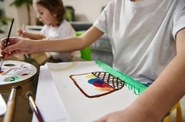 Kapalı alan yaratıcılığı dersleri için suluboya tekniği uygulayan çocuğun elini kapat. Paskalya konsepti