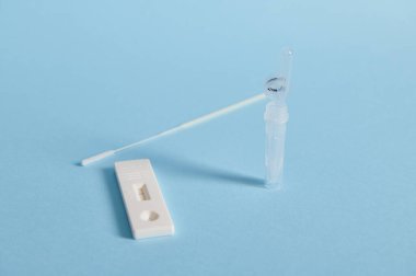 Bir covid-19 hızlı antijen testinin kapanışı mavi arkaplan üzerinde izole edilmiş ve metin için boşluk