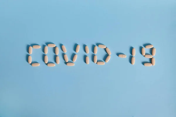 Inschrift Covid Aus Briefen Aus Medizinischen Tabletten Auf Blauem Hintergrund — Stockfoto