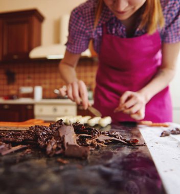 Bulanık çikolatanın arka planındaki mermer masada uzanan ve ev yapımı çikolatalı trüf mantarı hazırlamaya çalışan yumuşak çikolata kütlesine odaklanın.