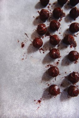 Erimiş çikolataya batırılmış çikolatalı trüf mantarı ve fırın için parşömen kağıdına kakao tozu ile parıldayan kakao. Metin için boşluk