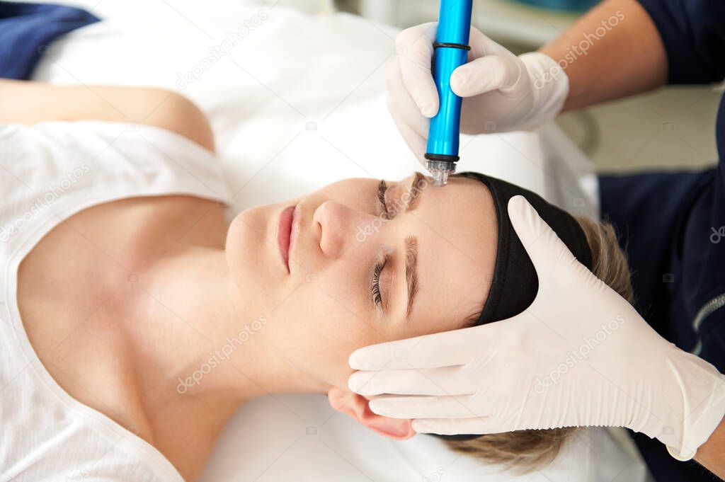Woman getting facial hydro microdermabrasion peeling treatment at spa center. Hydra Vacuum Cleaner. Exfoliation, Rejuvenation And Hydratation. Skin care concept