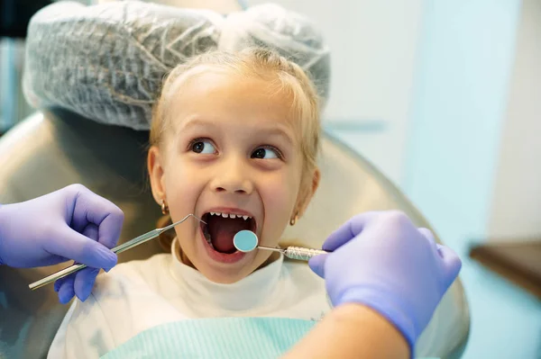牙科医生检查时张嘴的可爱的孩子 定期看牙医以及早诊断和治疗牙病的概念 — 图库照片