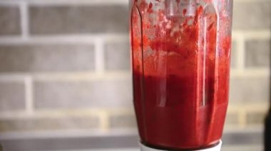Blender kasesinde meyve püresi pişirmek, kasenin duvarlarına çilek püresi dökmek. Yavaş çekim video görüntüleri