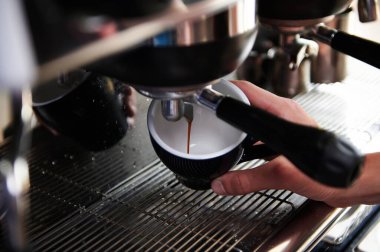 Kahve makinesinden fincanlara dökülen espresso yakın plan. Profesyonel kahve demleme..