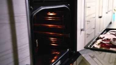 Pizza tepsisini elektrikli fırına koyuyorum. Yan görüş. Video görüntüleri