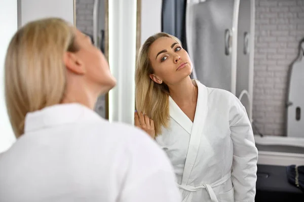 Gorgeous Woman White Robe Touches Her Blonde Hair Admiring Her — Stok fotoğraf