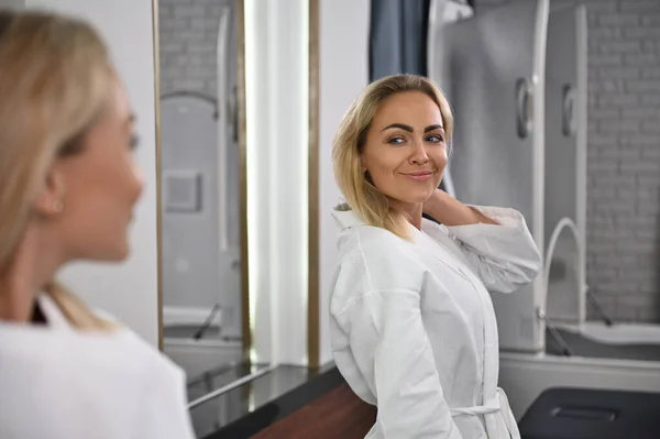 Gorgeous Woman Smiles Looking Her Mirror Reflection Woman Spa Resort — Foto de Stock