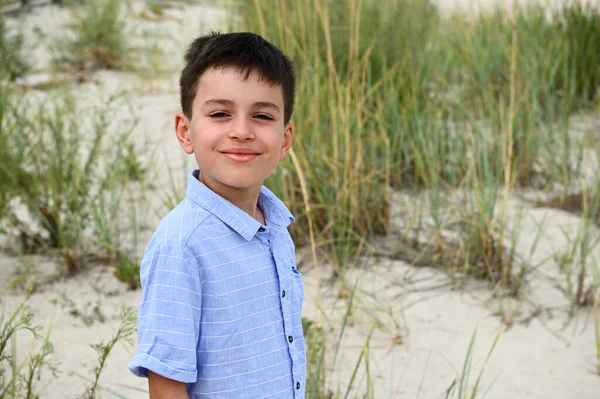 草原の厚さと砂の土壌を背景に かわいい笑顔の10代の少年の顔のクローズアップ ハンサムな子供かわいい笑顔カメラを見て — ストック写真