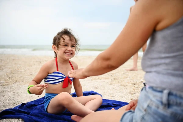 Urocza Dziewczynka Odpoczywająca Plaży Grająca Gry Matką Słodka Uśmiechnięta Pozująca — Zdjęcie stockowe