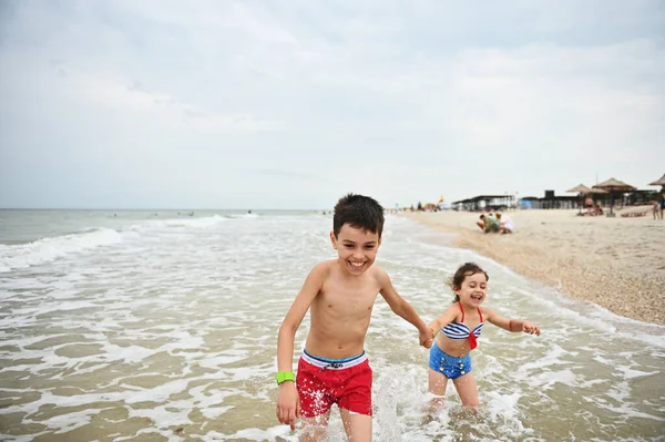 Niño Encantador Coge Mano Hermana Menor Corre Alegremente Largo Orilla — Foto de Stock