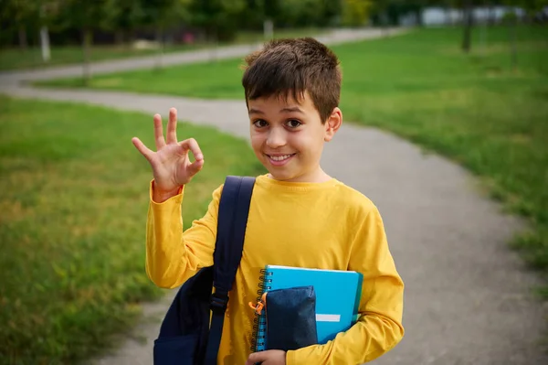 Snygg Söt Skolpojke Visar Sjunga Med Handen Står Med Skolväska — Stockfoto