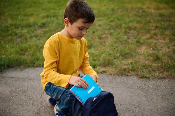 Adorável Menino Escola Idade Elementar Bonito Senta Joelhos Caminho Parque — Fotografia de Stock