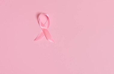 Ekim ayında göğüs kanseri farkındalığı ayının uluslararası sembolü olan saten pembe kurdele farkındalığı. Pembe arka planda fotokopi alanı ile izole edilmiş. Kadın sağlığı ve sağlık hizmetleri kavramı.