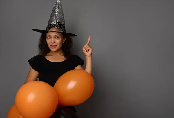 Fröhliche Hispanische Frau Mit Zauberhut Schwarz Gekleidet Hält Orangefarbene Aufgeblasene — Stockfoto