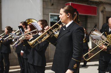 Quesada, Endülüs, İspanya. 18 Nisan 2024. Bir kadın trompetçi sokak performansı sırasında bandoya liderlik ediyor. Müziği, takım çalışmasını ve halka açık kutlamaları yakalıyor..