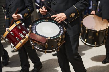 Resmi üniformalı bir grup davulcu koordine bir sokak geçidi düzenliyor, sopa sallıyor ve kapanlara vuruyor. Quesada, Endülüs, İspanya. 18 Nisan 2024.