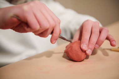 Pembe kilden bir topu şekillendirmek için yakın plan çekimler, odaklanma, yaratıcılık ve ev yapımı aktiviteleri.