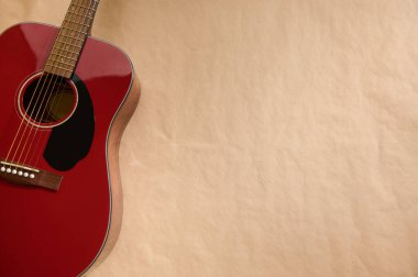 Gitar bakımını, tamir tekniklerini ve müzisyenler ve Luthiers için enstrüman bakımını gösteren, sicim ayarlamalarını ve değişimlerini gösteren kırmızı akustik gitarın yakın çekimi.