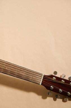 Akustik gitar ensesi ve başlığının yakın plan çekimi. Telleri ayarlama ve değiştirme, gitar bakımı, müzisyenler ve Luthiers için akustik akustik gitar ayarlama ve onarım kavramları..