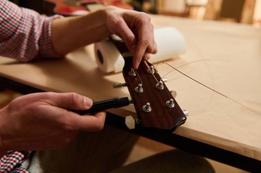 Eller gitar tellerini akustik bir başlıkta değiştirir ve ayarlar, gitar bakımını gösterir, müzisyenler ve enstrüman bakımı teknikleri yeniden dizilir ve tamir edilir.