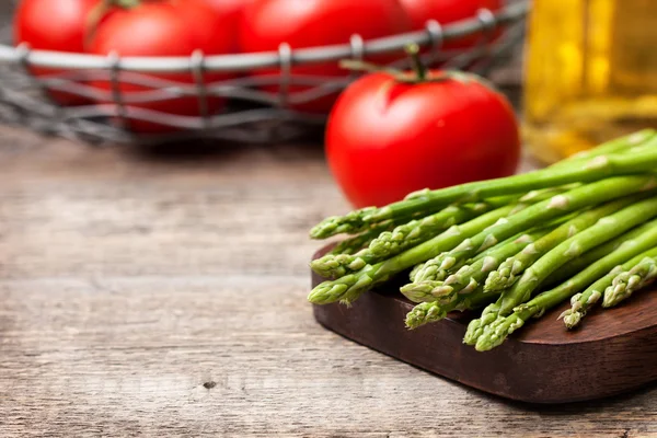 Fresh asparagus, tomatoes, olive oil — Stock Photo, Image