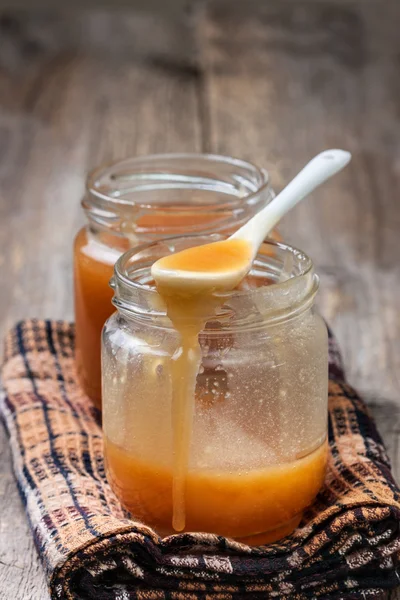 Caramel sauce in glass jars — Stok fotoğraf