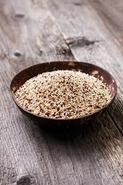 Quinoa em uma tigela em um fundo de madeira — Fotografia de Stock