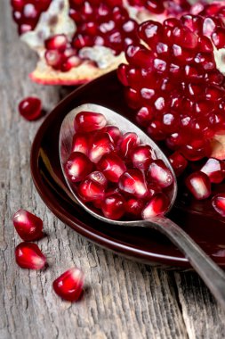 Old spoon with pomegranate seeds