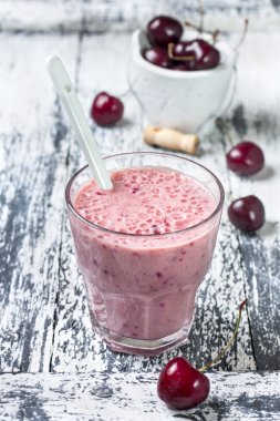 Smoothie with cherries on a wooden background