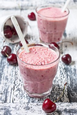Smoothie with cherries on a wooden background