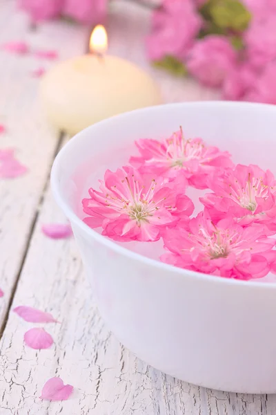 Sakura fiori e candele in una ciotola bianca — Foto Stock