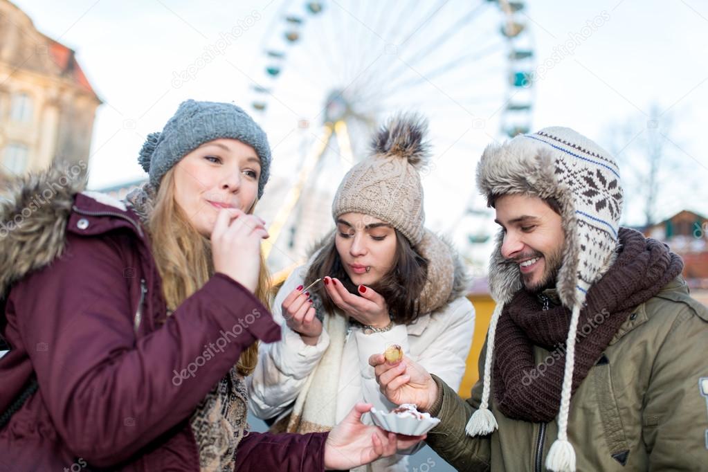 Couple, man, woman, friends have fun at the Christmas Market
