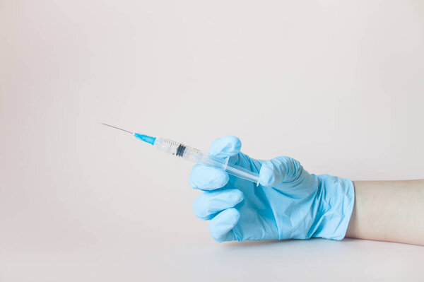 Syringe in hands in protective medical rubber gloves