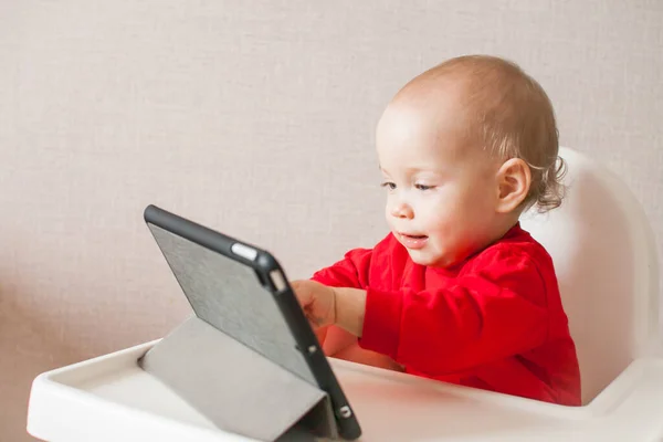 Tutkulu küçük bir kız bir tabletten online eğitim programı izliyor. Çizgi film izliyorum..