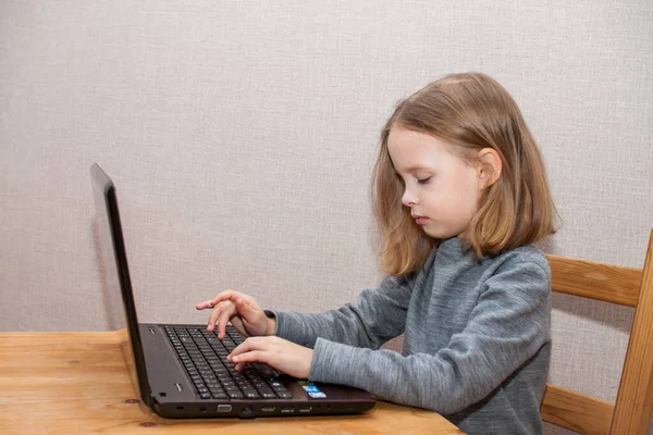 Küçük kız ödev yapıyor ve internetten öğreniyor, uzaktan.