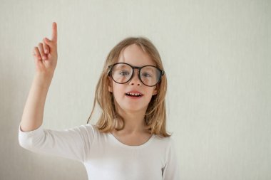 Gözlüklü küçük kız ev ödevi yapıyor, kitap okuyor..