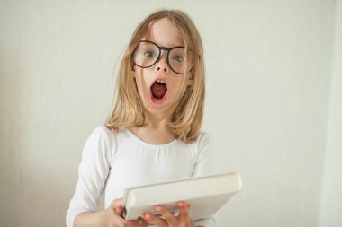 Gözlüklü küçük kız ev ödevi yapıyor, kitap okuyor..