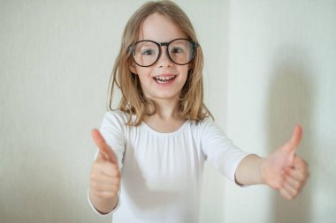 Gözlüklü küçük kız ev ödevi yapıyor, kitap okuyor..