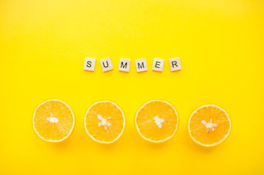 Yazın ahşap küplerden ve parlak sarı arkaplanda portakallardan bir yazı.