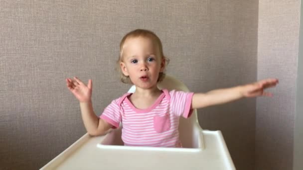 Kleines Mädchen spielt fröhlich, klopft mit den Händen auf den Tisch — Stockvideo