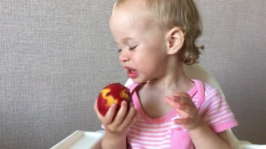 Küçük kız zevk ve ilgiyle sulu nektarin yer ve tadar.