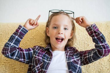 Ekose gömlekli ve gözlüklü neşeli kız. Çevrimiçi öğrenme kavramı.