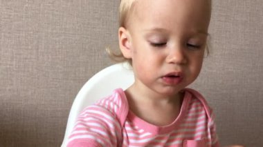 Küçük kız zevk ve ilgiyle çilek yer ve yer.