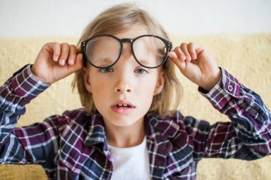 Ekose gömlekli ve gözlüklü yorgun, uykulu kız. Çevrimiçi öğrenme kavramı.