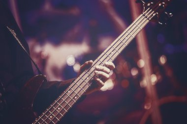 Bas gitar çalan gitarist elin yakın görünümü