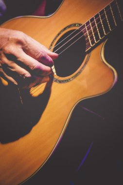 Close up view of guitarist hand playing acoustic guitar clipart