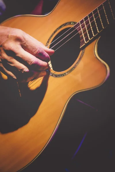 Akustik gitar çalan gitarist elin yakın görünümü